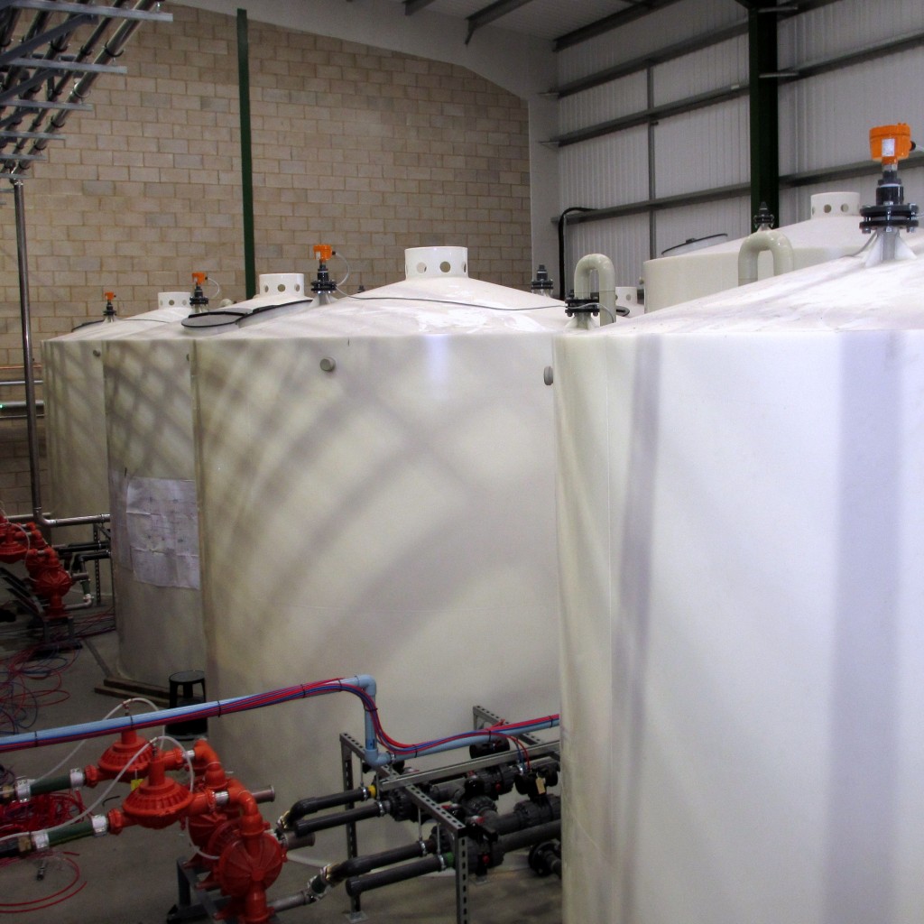 Series of Indoor Plastic Storage Tanks with Sloping Bases To Allow Maximum Drainage Out of Tank